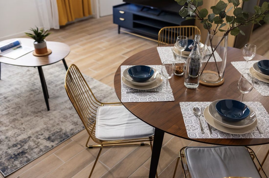 Table ronde dressée, chaises dorées et vaisselle bleue