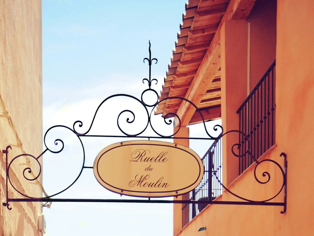 Ruelle en escalier du vieux village de Bormes-les-Mimosas, enseigne en fer forgé